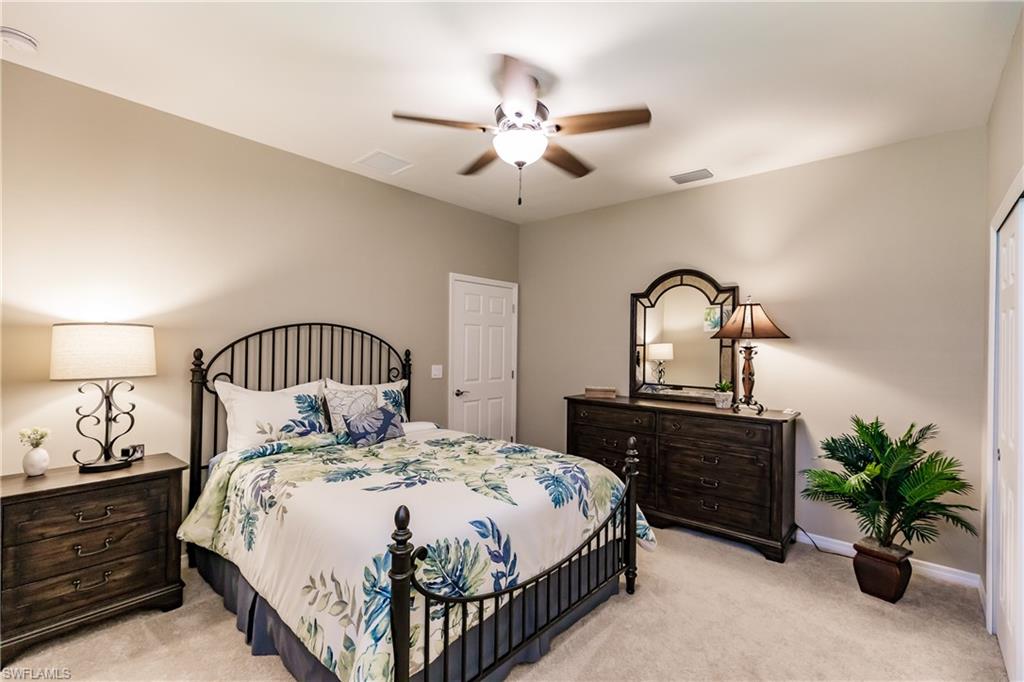 10883 Dennington Road Fort Myers, FL 33913 - Photo 17 of 32 a bedroom with a bed and a chandelier