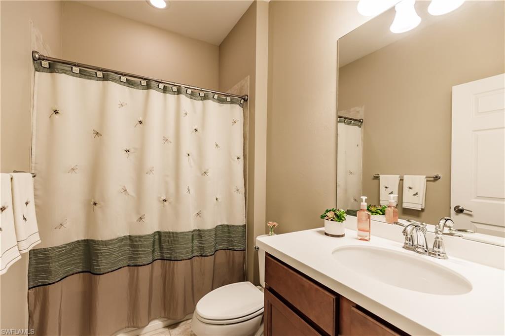 10883 Dennington Road Fort Myers, FL 33913 - Photo 20 of 32 a bathroom with a sink a toilet a mirror and shower curtain