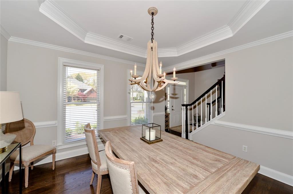 310 Windsor Gate Cove Northeast Atlanta, GA 30342 - Photo 14 of 58 a dining room with wooden floor a chandelier a wooden table and chairs