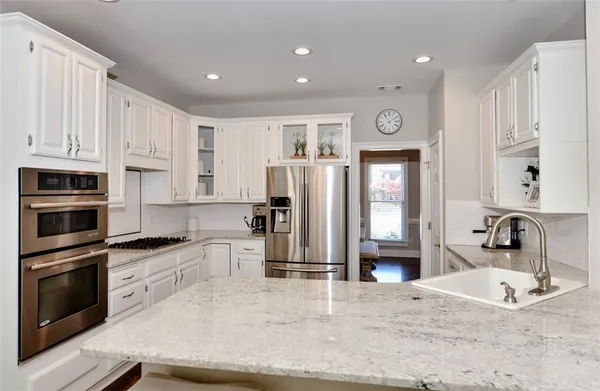 a large kitchen with lots of counter space and furniture