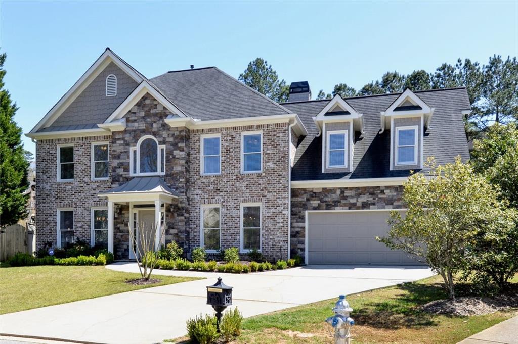 310 Windsor Gate Cove Northeast Atlanta, GA 30342 - Photo 2 of 58 a front view of a house with a yard