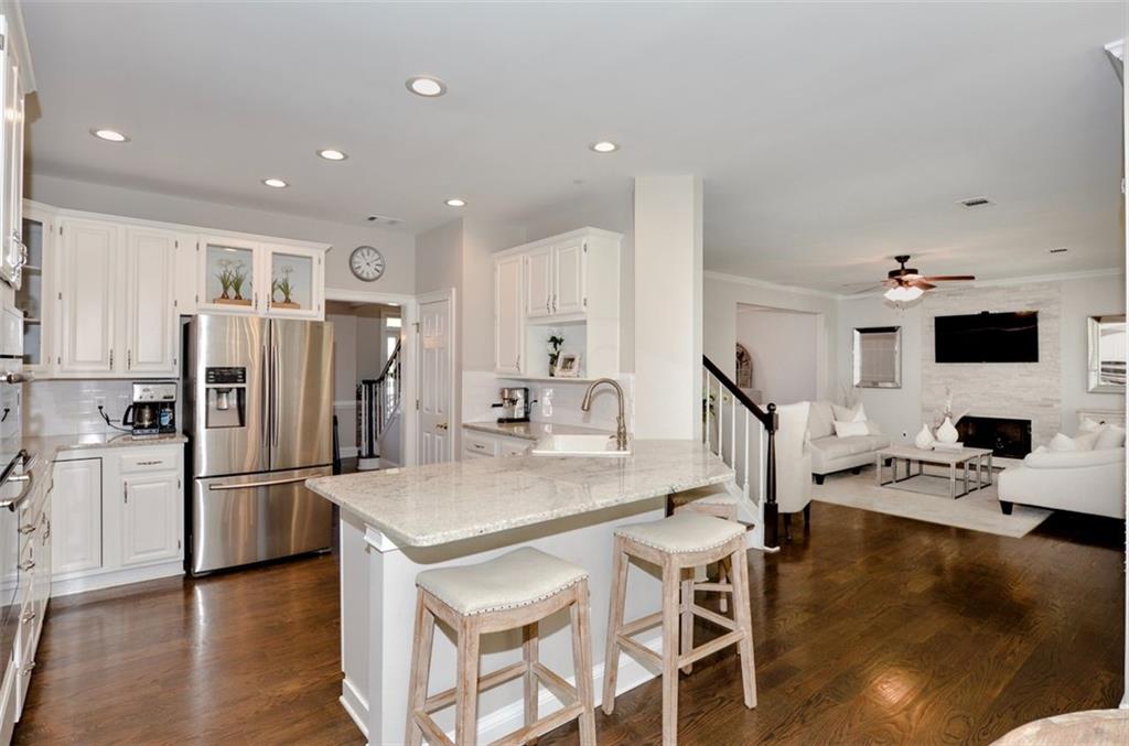 310 Windsor Gate Cove Northeast Atlanta, GA 30342 - Photo 22 of 58 a kitchen with stainless steel appliances granite countertop a refrigerator stove microwave and sink