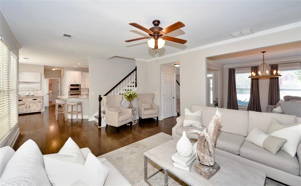 310 Windsor Gate Cove Northeast Atlanta, GA 30342 - Photo 25 of 58 a living room with fireplace furniture and a wooden floor