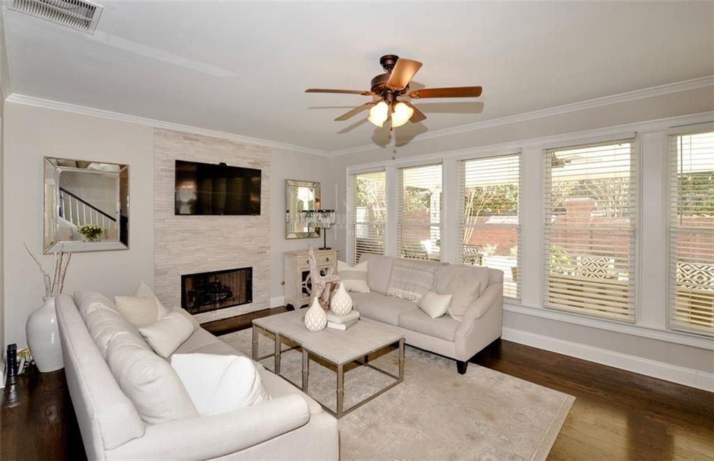310 Windsor Gate Cove Northeast Atlanta, GA 30342 - Photo 27 of 58 a living room with furniture a flat screen tv and a fireplace