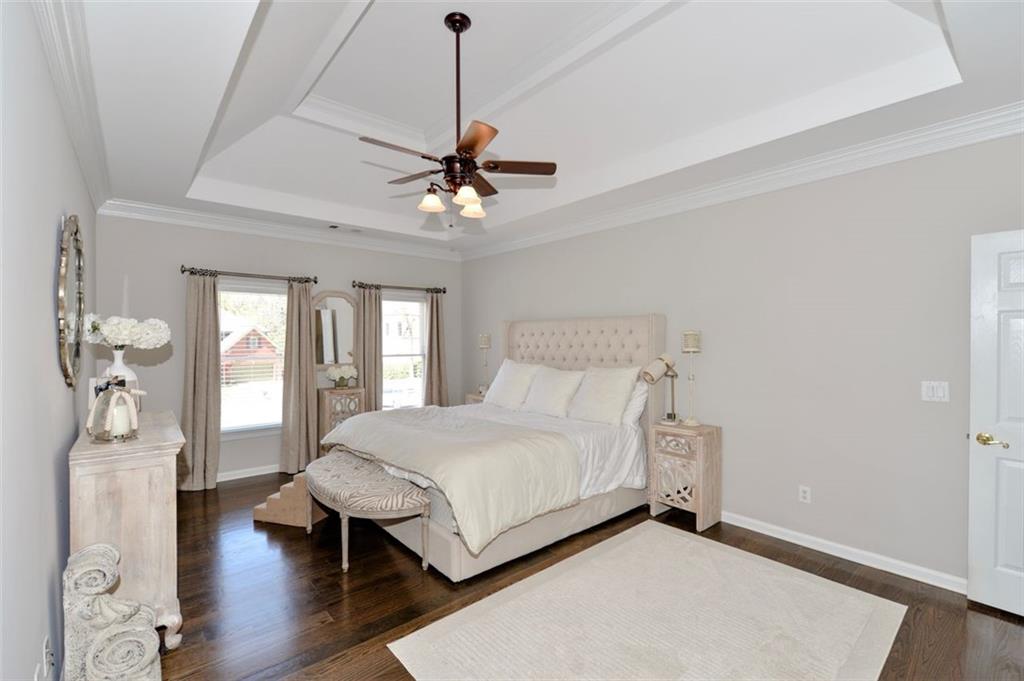 310 Windsor Gate Cove Northeast Atlanta, GA 30342 - Photo 36 of 58 a bedroom with a bed and wooden floor