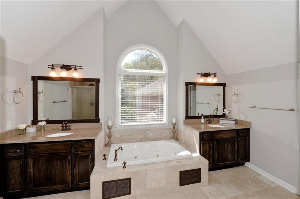 310 Windsor Gate Cove Northeast Atlanta, GA 30342 - Photo 40 of 58 a bathroom with a sink double vanity granite tub shower and mirror