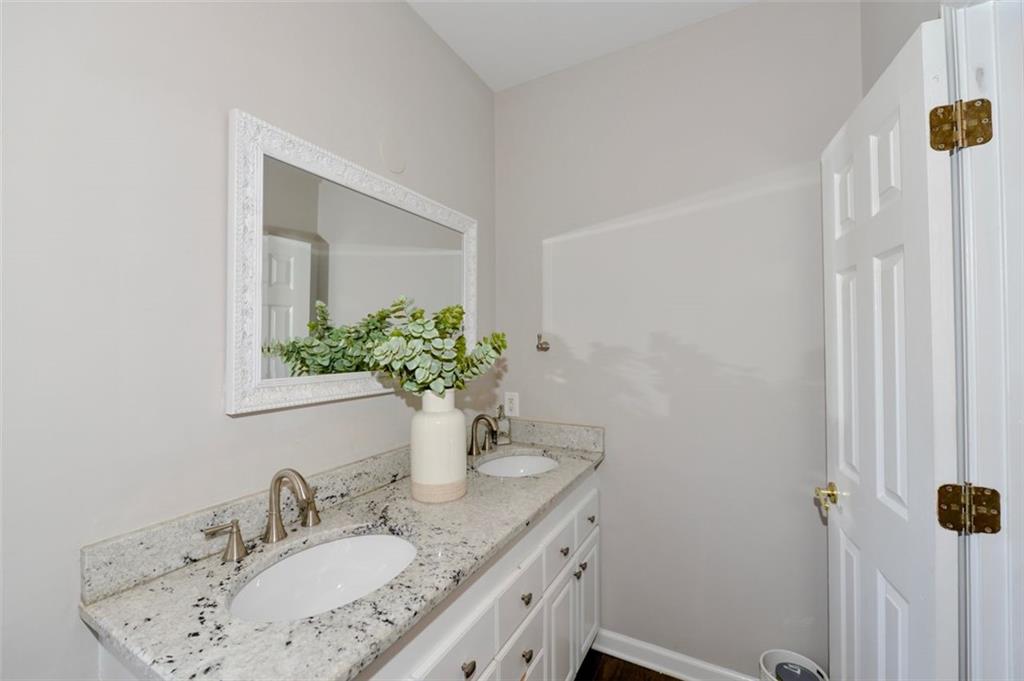 310 Windsor Gate Cove Northeast Atlanta, GA 30342 - Photo 50 of 58 a bathroom with a granite countertop sink and a mirror