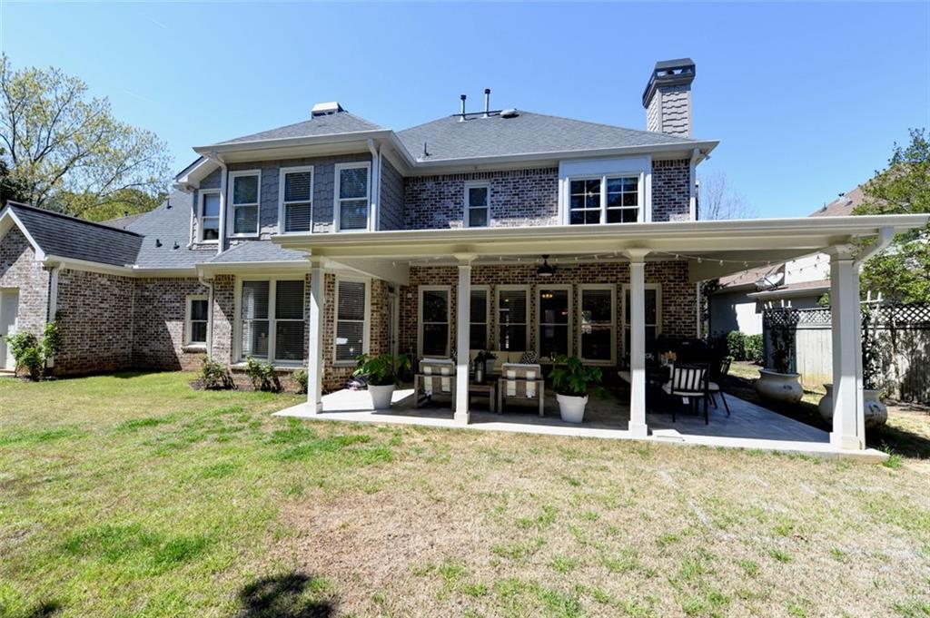 310 Windsor Gate Cove Northeast Atlanta, GA 30342 - Photo 6 of 58 front view of a brick house with a yard