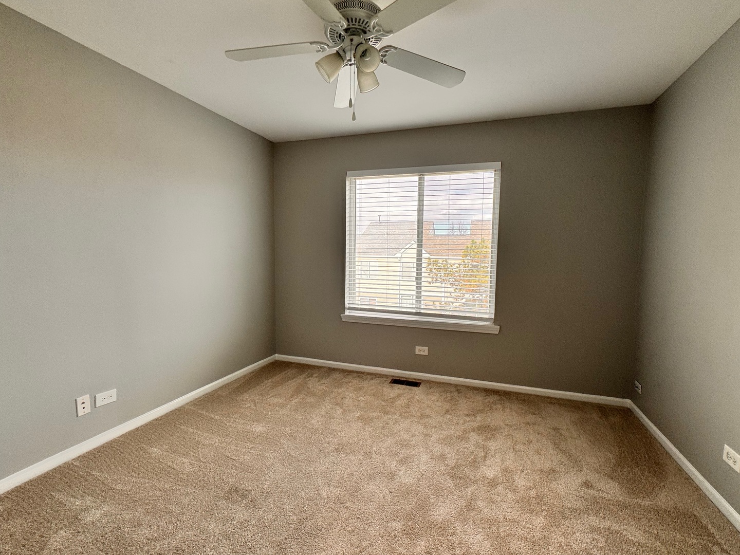 1617 Spaulding Road Bartlett, IL 60103 - Photo 9 of 10 an empty room with a chandelier fan and windows