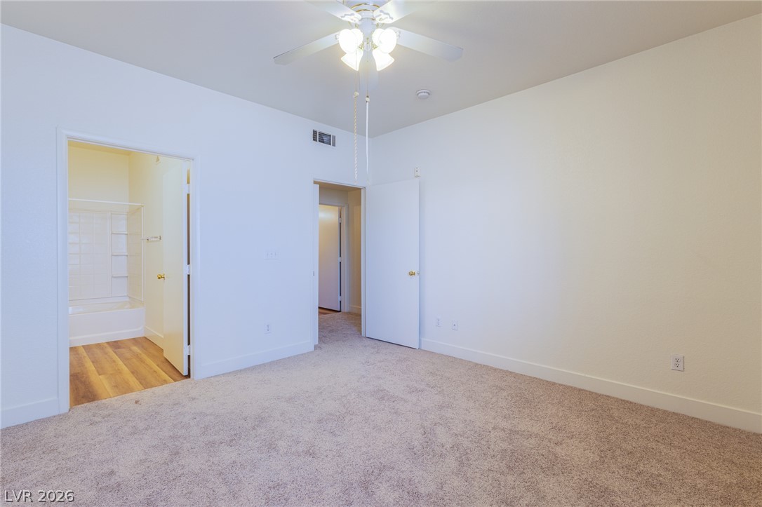 9050 West Warm Springs Road, Unit 1011 Las Vegas, NV 89148 - Photo 15 of 32 A comfortable bedroom with soft carpet flooring and direct access to a functional bathroom.