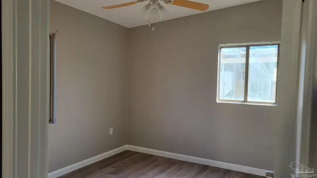 an empty room with a window and a fan