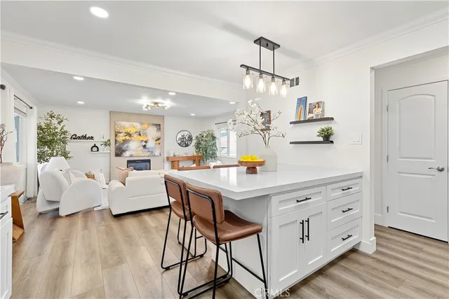 a view of a dining room and livingroom with furniture wooden floor a chandelier