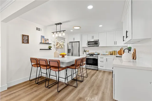 a kitchen with a table chairs microwave and cabinets