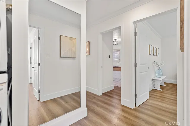 a view of a hallway with wooden floor and a living room