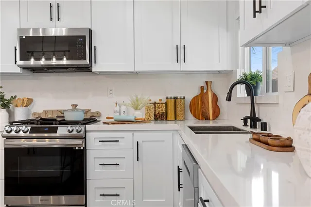 a kitchen with stainless steel appliances granite countertop a sink a stove and a microwave