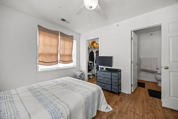 a bedroom with a bed and wooden floor