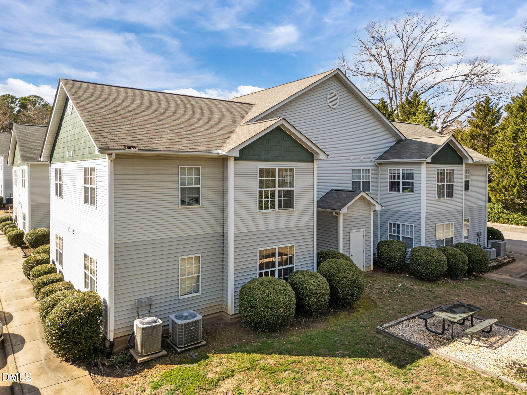 1303 Kent Road, Unit 204 Raleigh, NC 27606 - Photo 23 of 26 a view of a white house next to a yard with plants and seating space