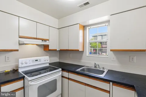 a kitchen with stainless steel appliances a sink stove and cabinets