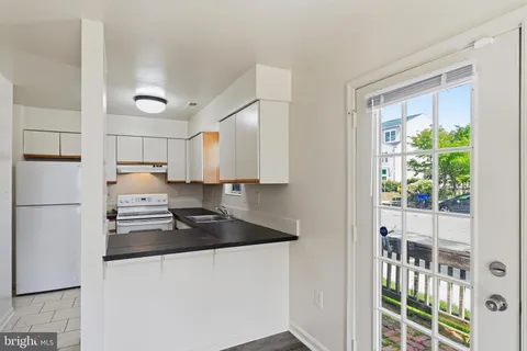 a kitchen with kitchen island a counter top space wooden floor and stainless steel appliances