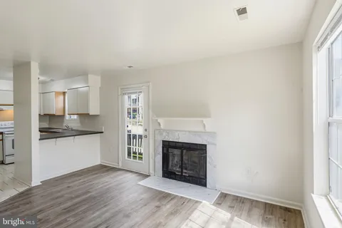 a view of a kitchen with a sink a fireplace and wooden floor