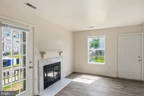 a view of an empty room with window and fire place