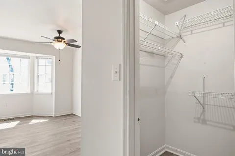 a view of a hallway with a ceiling fan and window
