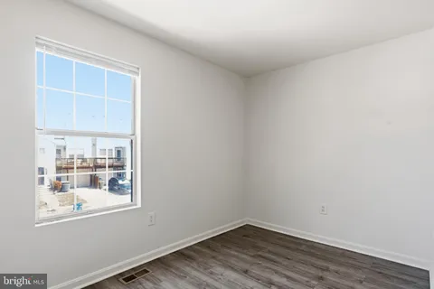 a view of a small space with wooden floor and a window