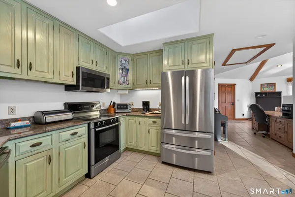 a kitchen with stainless steel appliances granite countertop a refrigerator oven a sink dishwasher and a refrigerator