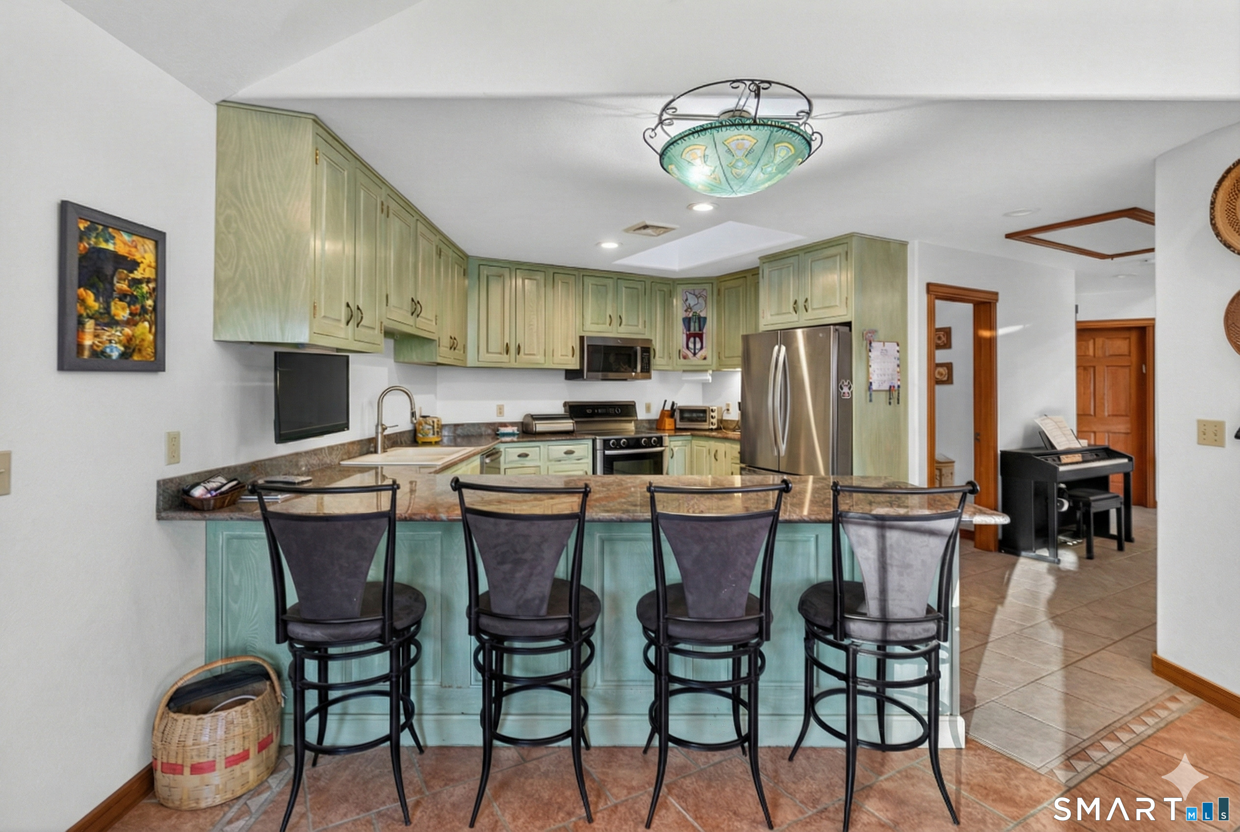 349 South Bigelow Road Hampton, CT 06247 - Photo 7 of 40 a kitchen with stainless steel appliances kitchen island granite countertop a table chairs and a refrigerator