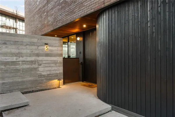 a view of a hallway with wooden floor and a bathroom