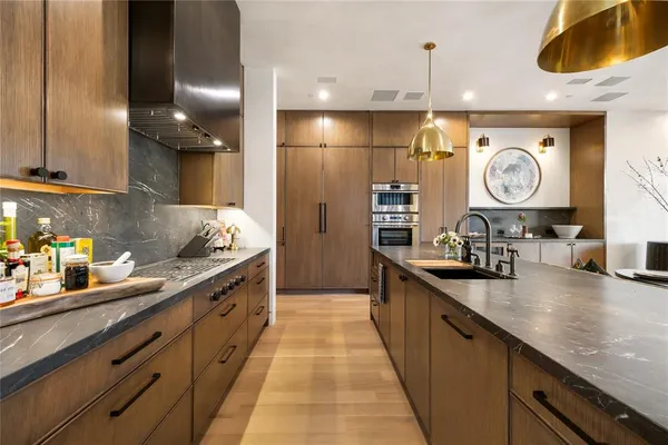 a kitchen with stainless steel appliances kitchen island granite countertop a stove a sink a dining table and chairs