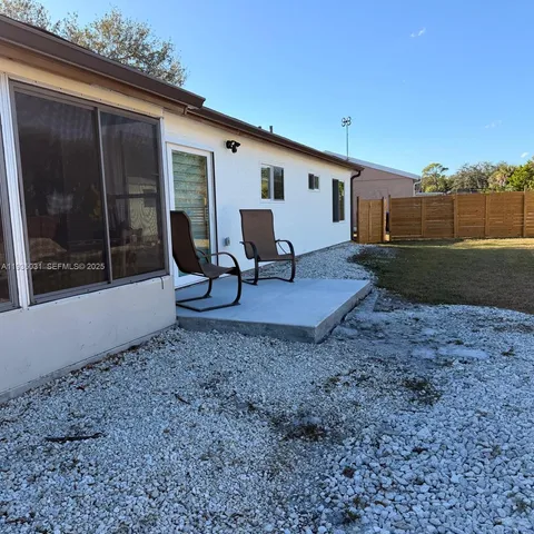 a view of a backyard with furniture and garden