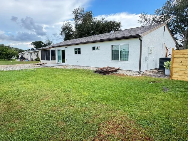 a big white house with a big yard and large trees