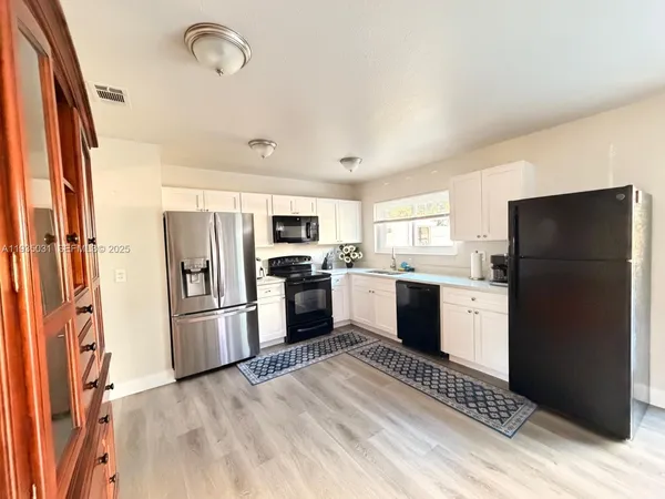 a kitchen with stainless steel appliances a refrigerator sink and microwave