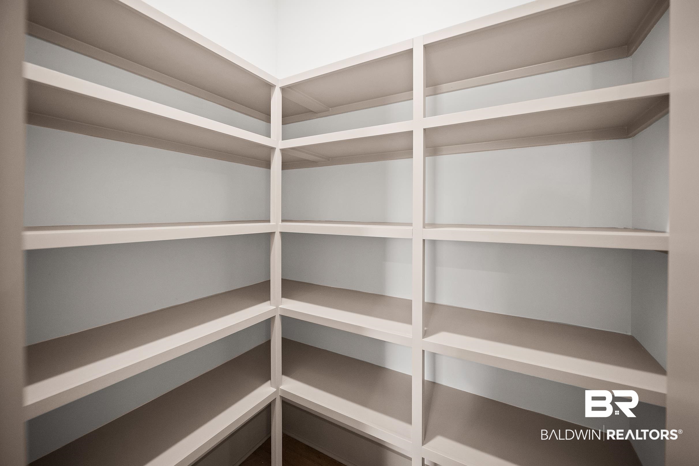 13111 Gopher Court Elberta, AL 36530 - Photo 13 of 41 Corner shelving unit featuring multiple levels of white-painted shelves