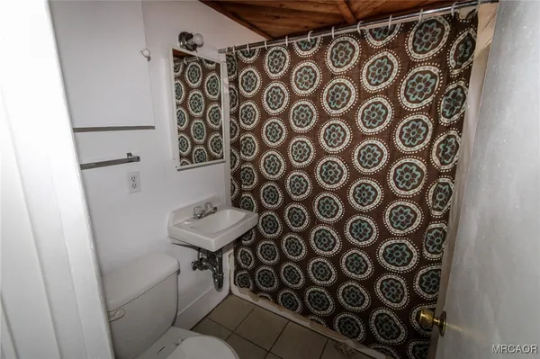 a bathroom with a sink and mirror with toilet