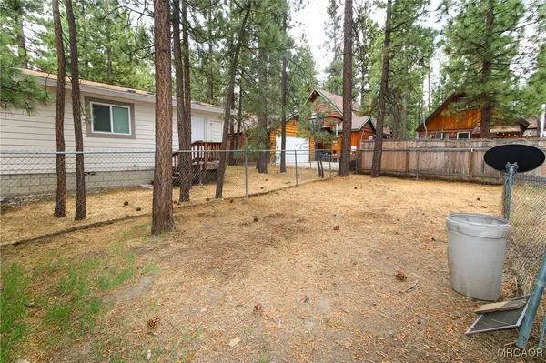 a view of a backyard that has a tree on the side of it