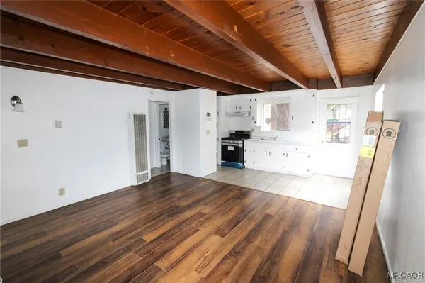 a view of empty room with wooden floor