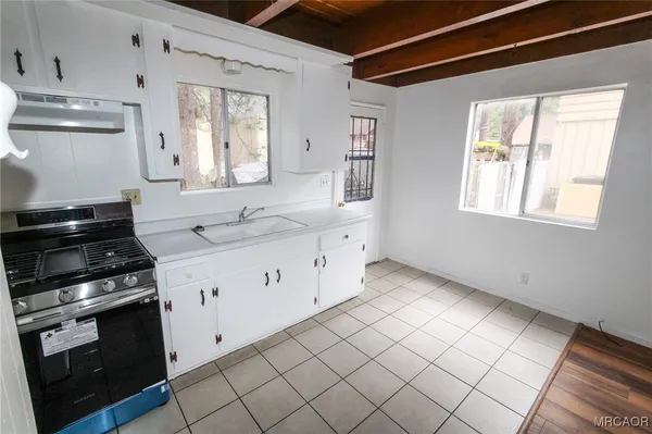 a kitchen with granite countertop white cabinets and appliances