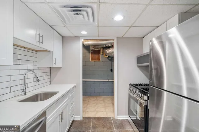 a kitchen with a sink a refrigerator and cabinets