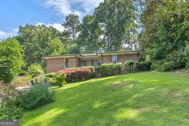 a view of a house with garden and a sitting area