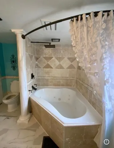 an empty room with chandelier fan and windows