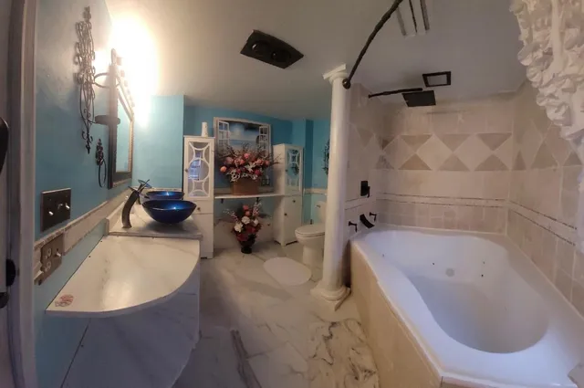 a open kitchen with stainless steel appliances granite countertop a stove top oven a sink a dining table and chairs with wooden floor