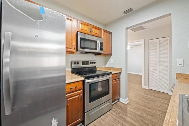 a kitchen with stainless steel appliances granite countertop a stove a microwave and a refrigerator