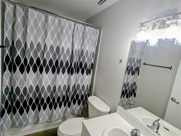 a bathroom with a toilet and a shower curtain