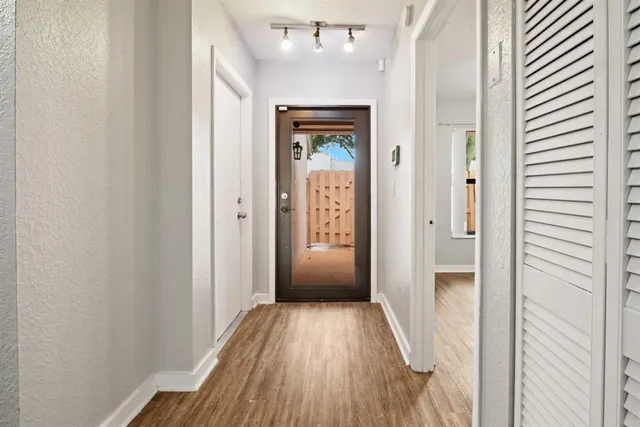 a view of a hallway with wooden floor