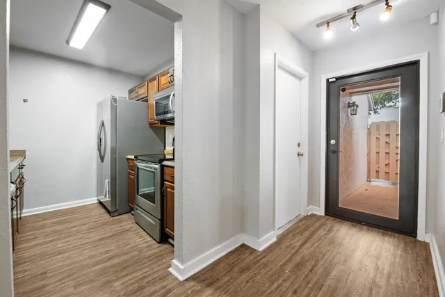 a view of empty room with wooden floor