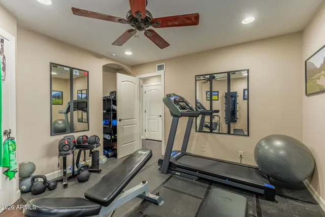 a living room with furniture a flat screen tv and a refrigerator