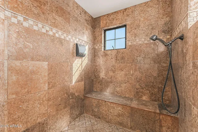 a living room with furniture kitchen area and a wooden floor