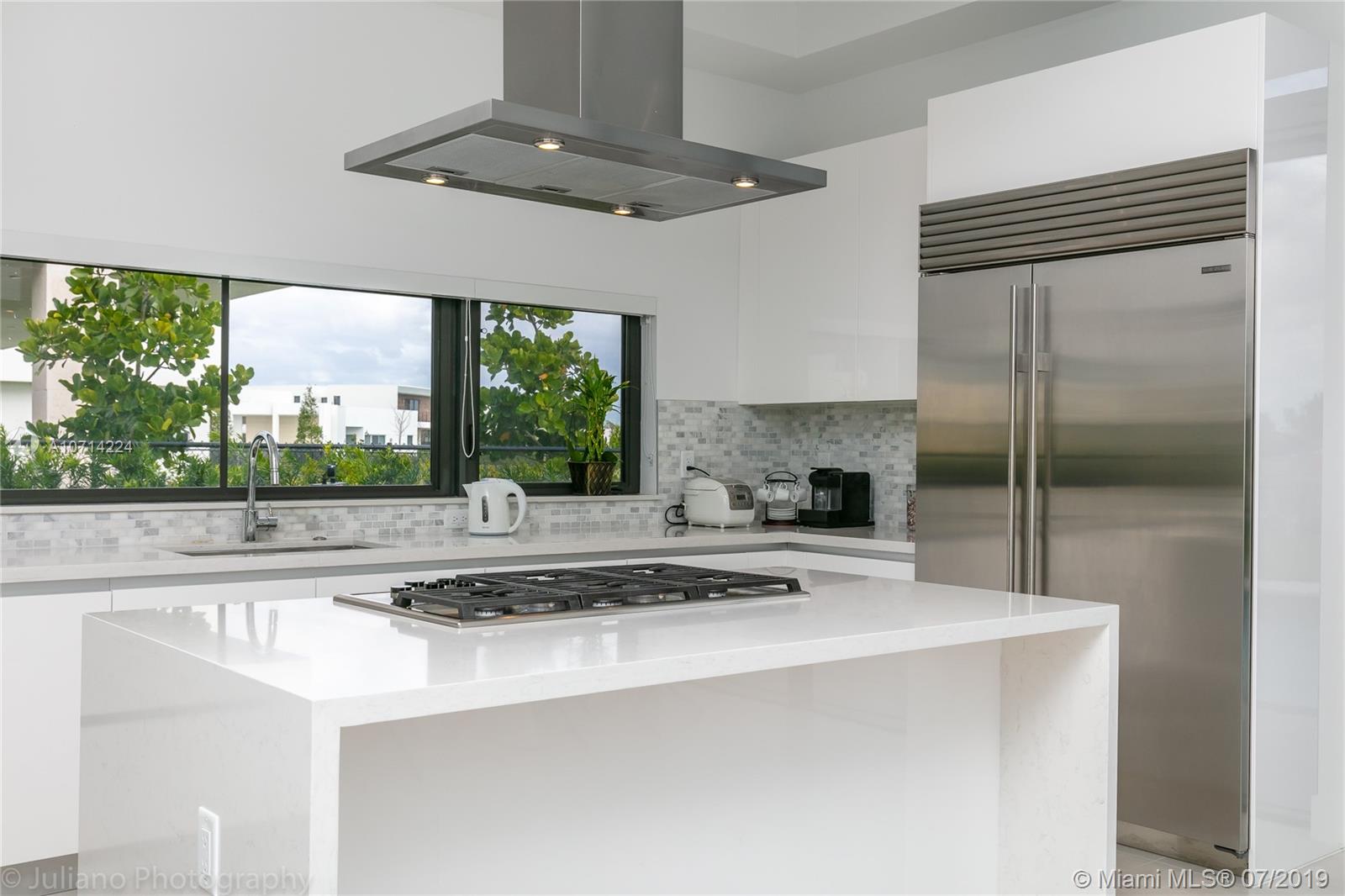 16630 Sunset Way Weston, FL 33326 - Photo 7 of 17 a kitchen with stainless steel appliances a sink a stove a refrigerator white cabinets and wooden floor